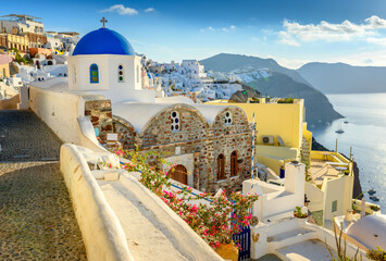 Picturesque view of the famous Greek resort Oia, Santorini island. Traditional village with white houses with blue domes over Caldera, Aegean Sea. Greece. Summer holidays.