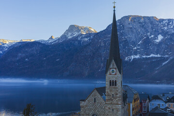 View of a small Austrian village of Hallstatt on a mountain foggy lake shore