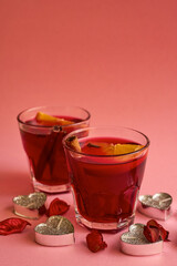Glasses with mulled wine, rose petals, candles on a pink background.Romantic evening. Valentine's Day. The 14th of February
