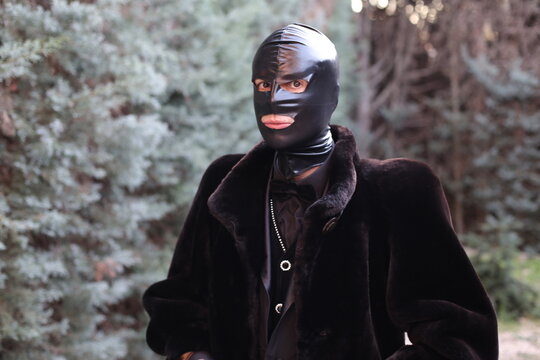 Androgynous Person Wearing Latex Black Mask In The Forest