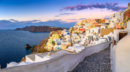 Fototapeta premium Picturesque sunset on famous view resort over Oia town on Santorini island, Greece, Europe. Summer holidays. Travel concept background.