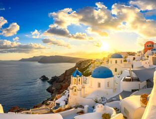 Obraz premium Picturesque sunset on famous view resort over Oia town on Santorini island, Greece, Europe. luxury travel. famous travel landscape. Summer holidays. Travel concept background.