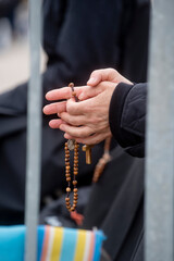 Hands holding a rosary at the Sanctuary of Our Lady of Fatima, Portugal
