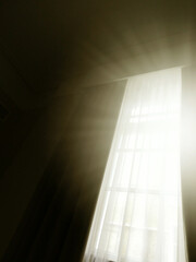 semi-abstract picture of long tall window with sunlight streaming in