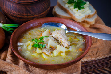Buckwheat soup with meat in a clay bowl on the table.