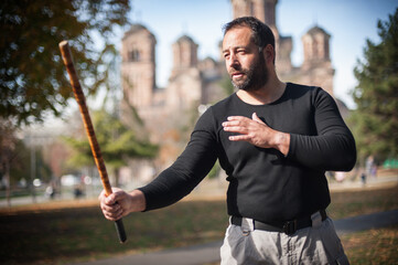 Escrima and kapap instructor demonstrates sticks fighting techniques in park