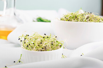 Microgreen sprouts on a plate against a white tablecloth