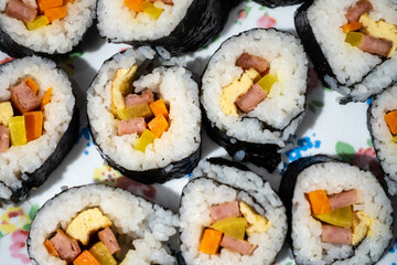 Homemade Korean kimbap or Japanese sushi rolls on a plate seen from above.