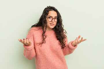 hispanic pretty woman feeling clueless and confused, not sure which choice or option to pick,...