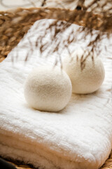 Natural wool dryer balls for more soft clothes while tumble drying in washing machine concept. Earthly tones, reed decoration. Discharge static electricity and shorten drying time, save energy.