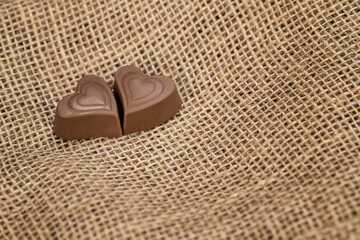 Chocolate hearts for valentines day on burlap background closeup