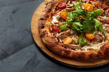 Pizza Caesar. Pizza with chicken, tomato, cheese and lettuce on stone background. Top view. Free space for your text. Delivery food