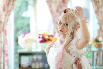 Beautiful young woman with white lolita dress with flowers garden Japanese fashion