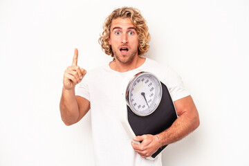 Young woman holding a scale isolated on white background having an idea, inspiration concept.