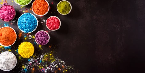 Poster Happy holi festival decoration.Top view of colorful holi powder on dark background with copy space for text. © Siam