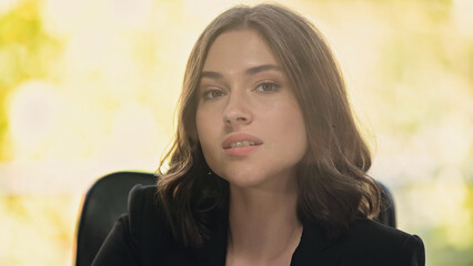 young brunette businesswoman looking at camera in office