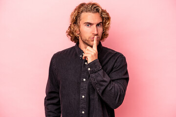 Young caucasian man isolated on pink background thinking and looking up, being reflective, contemplating, having a fantasy.