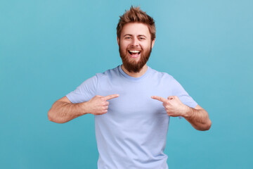 It's me! Portrait of ambitious bearded man with toothy smile, pointing fingers on himself, being...