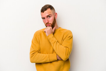 Young caucasian man isolated on white background suspicious, uncertain, examining you.