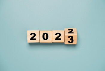 Wooden block cube flipping between 2022 to 2023 for change and preparation merry Christmas and happy new year. - obrazy, fototapety, plakaty