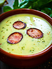Cream potatoes soup with sausages on wooden table
