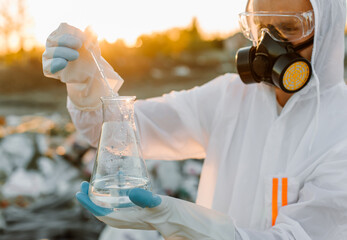 Close-up scientist examining sampling of toxic chemicals on polluted ground