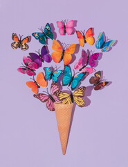 Colorful butterflies flying from ice cone on pastel purple background. 80s, 90s retro aesthetic...