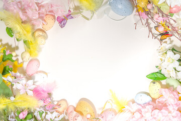 Obraz premium Easter holiday top view flat lay frame background with easter colorful eggs, and spring flowers. Spring holiday greeting card background, copy space