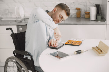 Young disabled man repairing motherboard at kitchen