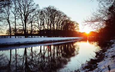 Sonnenuntergang über Fluss im Winter