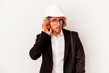 Young architect caucasian man with helmet isolated on white background trying to listening a gossip.