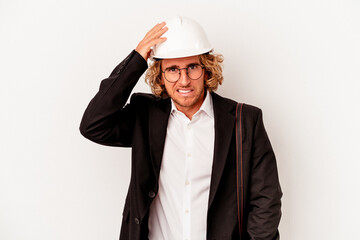 Young architect caucasian man with helmet isolated on white background being shocked, she has remembered important meeting.