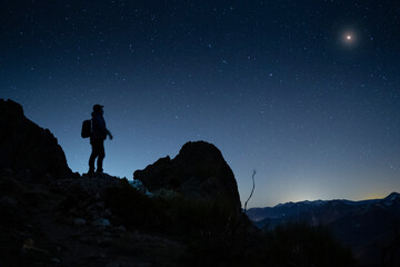 Fototapeta na wymiar hiker looking to the night sky in the mountains