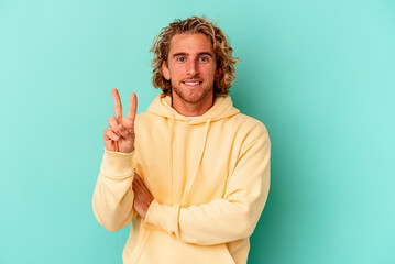 Young caucasian man isolated on blue background showing number two with fingers.
