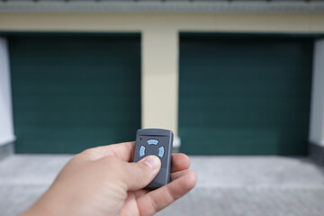 The man holds in his hand a remote control that opens the door of a double garage. A convenient key...