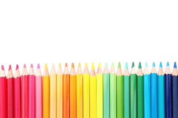 Colored pencils lined up on white paper background. Copy space. Back to school. Office supplies.