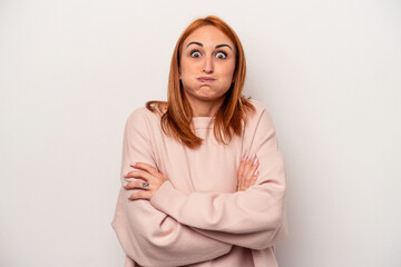 Young caucasian woman isolated on white background blows cheeks, has tired expression. Facial...