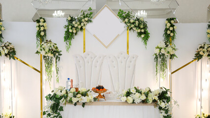 Wedding table of the bride groom decorated with flowers and greenery white background.