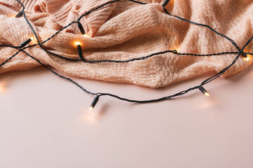 Pink cardigan with fairy lights on a pink background.