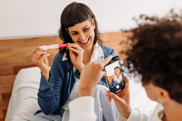 Cheerful young woman posing for a picture holding her pregnancy