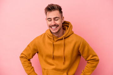 Young caucasian man isolated on pink background happy, smiling and cheerful.