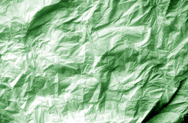 Crumpled white paper background in green tone.