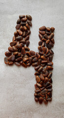 number four consists of large brown pine nuts on a background of gray marble created from natural materials