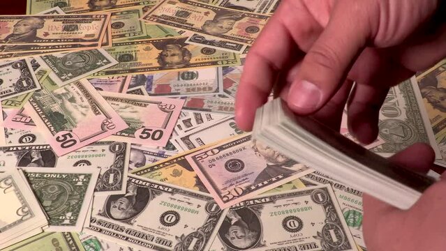 Hispanic male counting U.S. currency dollar bills notes money.