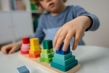 Beautiful toddler play with a wooden frame puzzle geometric figure toys at home. Toddler play with a color educational toy.  Child development.  Baby hands. View from above. Detail