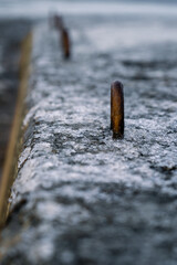 Rusty steel hooks covered in ice on a pier.