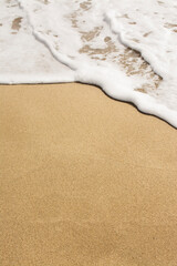 Waves and sand with copy space, close up.