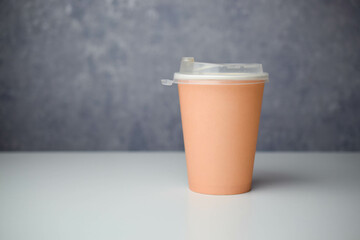 takeaway coffee cup of light brown color in the singular 