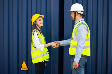 Caucasian Man manager and woman Supervisor dock cargo handshaking after good deal at container yard port of import and export goods. Unity and teamwork concept