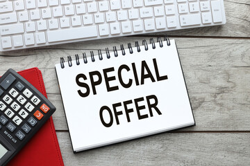 text on open notepad on wooden table near keyboard. Special Offer